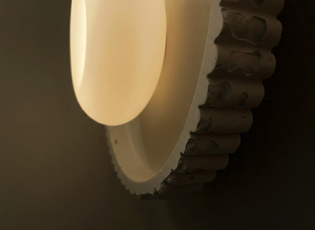 Round stone surface with a glowing white light fixture on a dark background